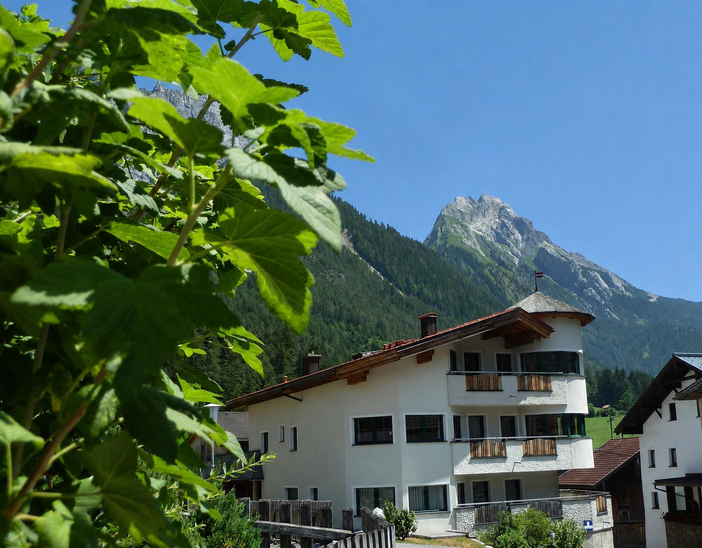 Apart Strolz vor der sommerlichen Berglandschaft von Schnann am Arlberg
