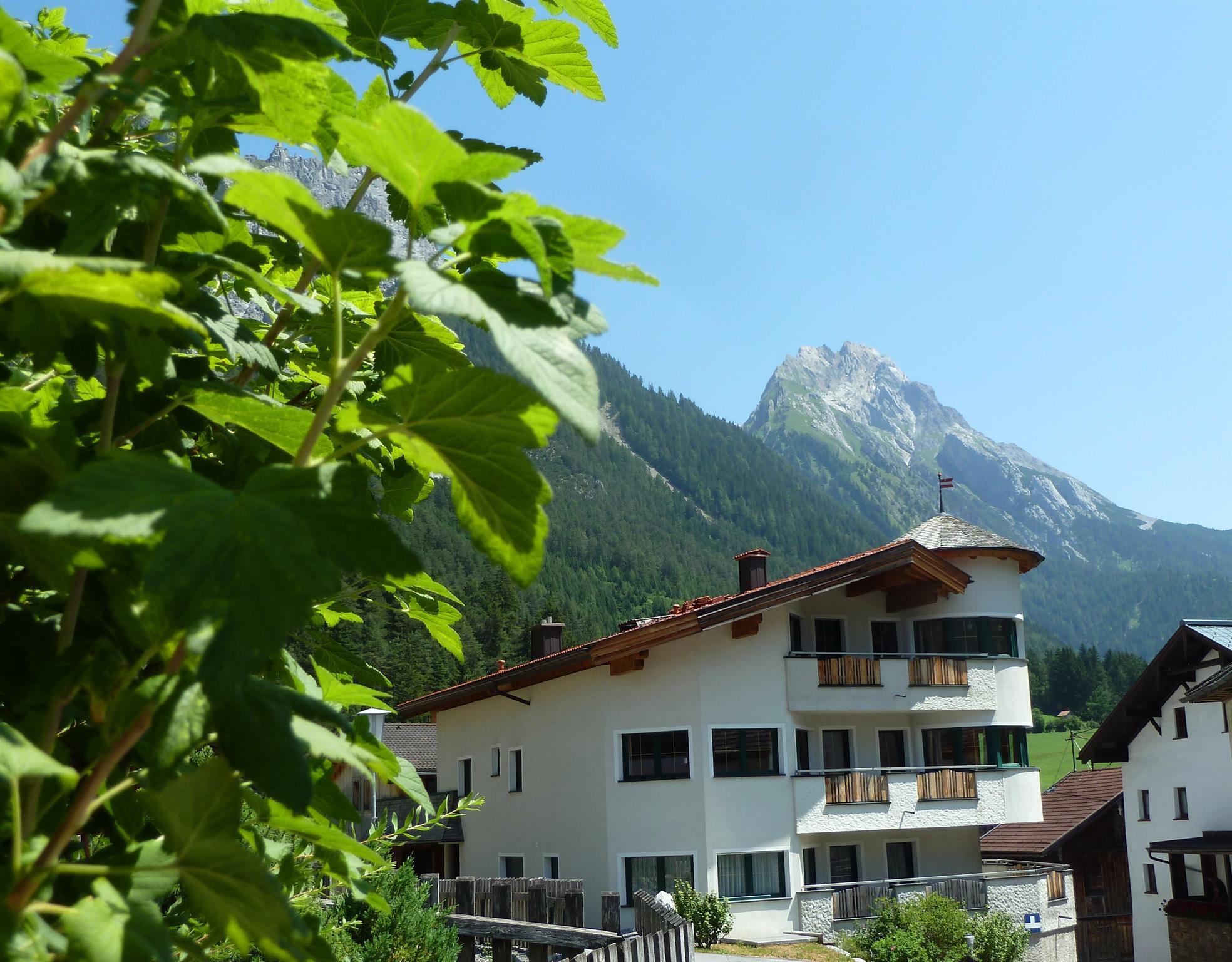 Apart Strolz vor der sommerlichen Bergwelt von Schnann am Arlberg
